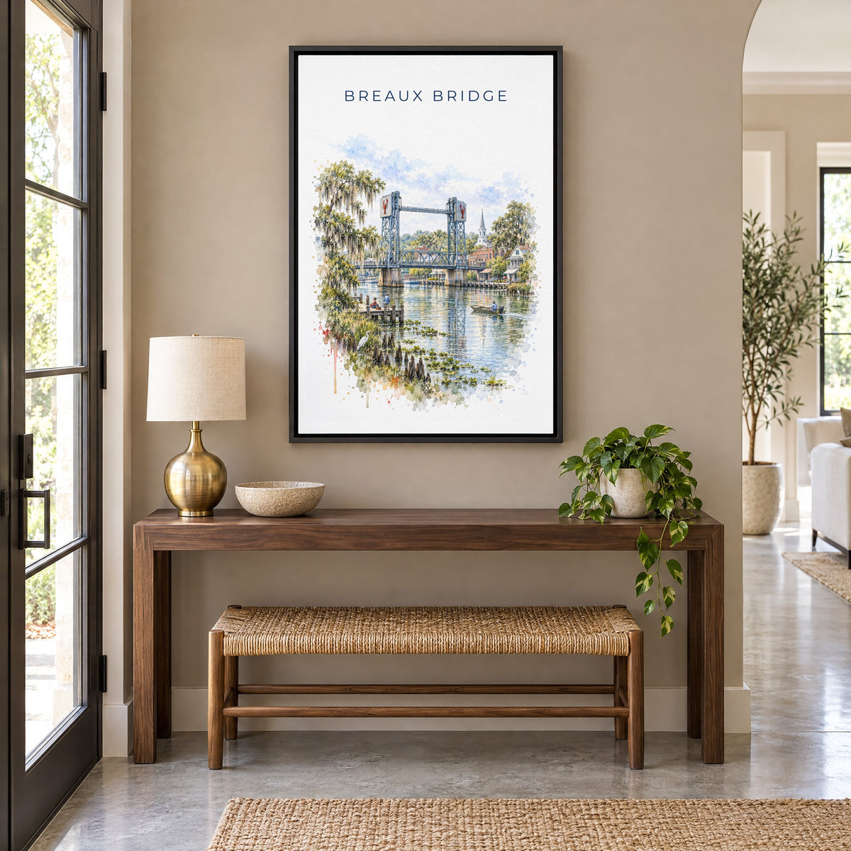 Breaux Bridge, Louisiana watercolor print as a black floater canvas above a walnut console and woven bench in an entryway