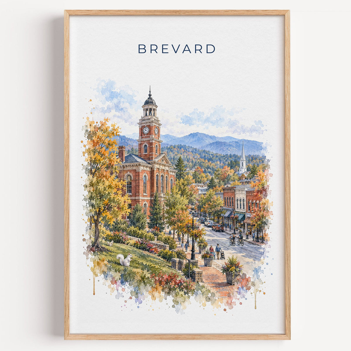 Brevard, North Carolina watercolor print in a light oak frame on a plain white wall