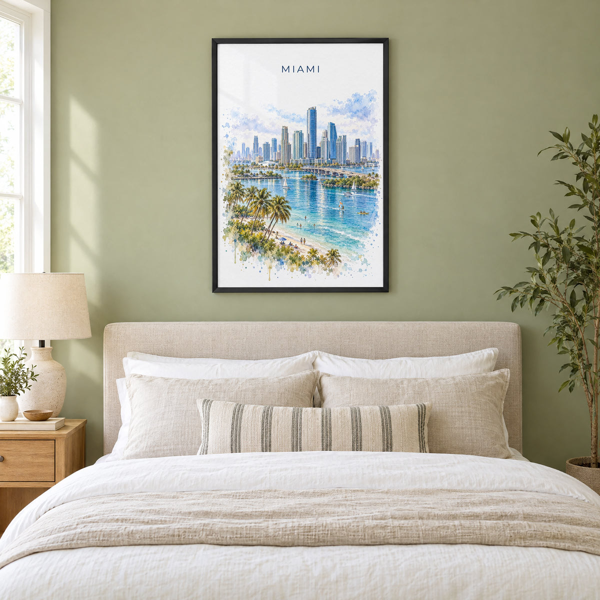 Brickell Miami watercolor print in a black frame above an upholstered headboard in a sage green bedroom