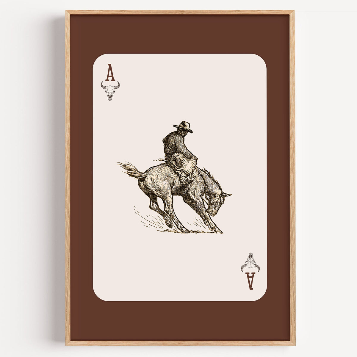 Bronco rider ace card print in a light oak frame on a plain white wall