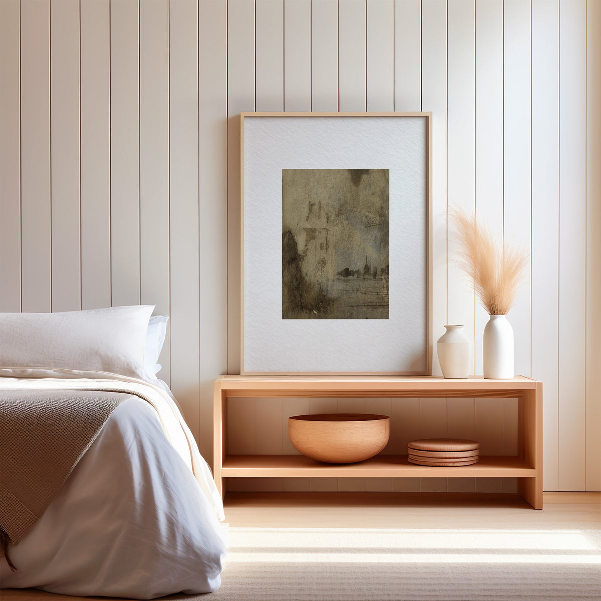 Brown wash ghost tower and waterline print in a light oak frame on a wood bench by a bed with pampas grass