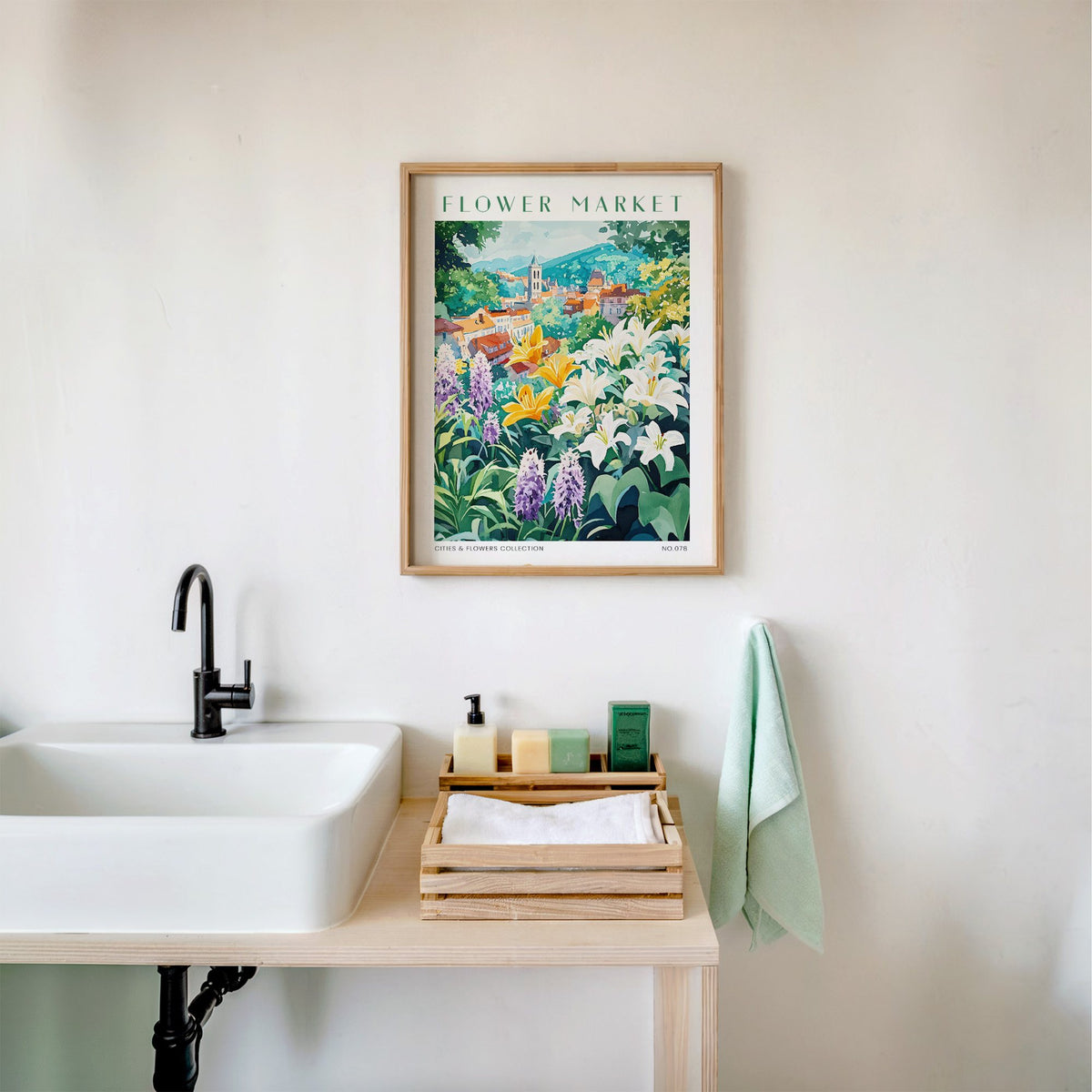 Bruges flower market print in an oak frame above a white bathroom sink with folded towels