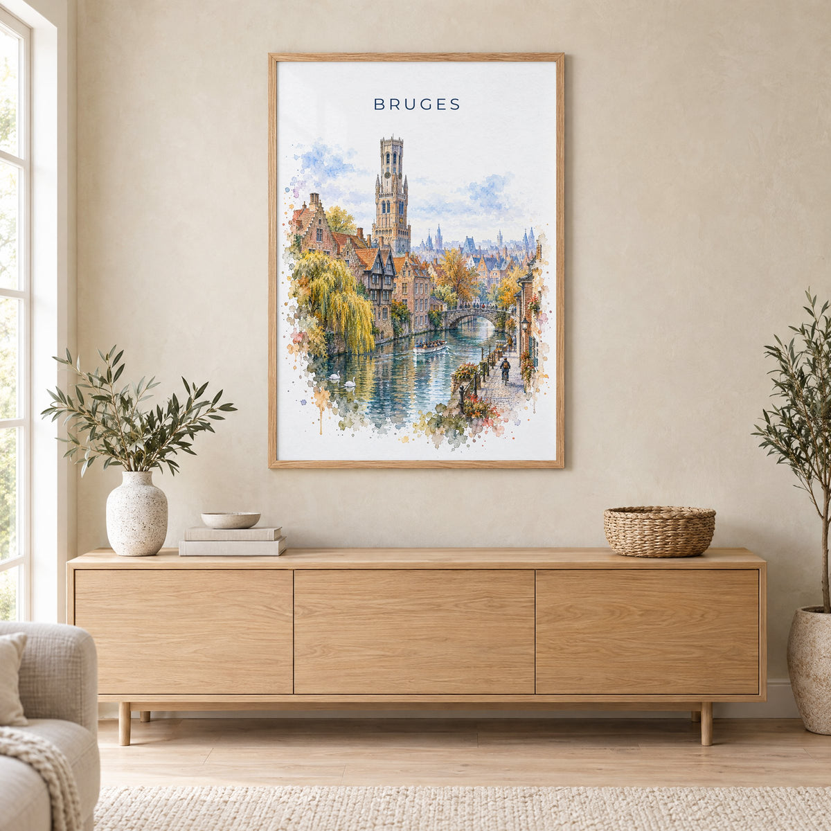 Bruges watercolor print in an oak frame above a light wood sideboard in a Scandinavian living room