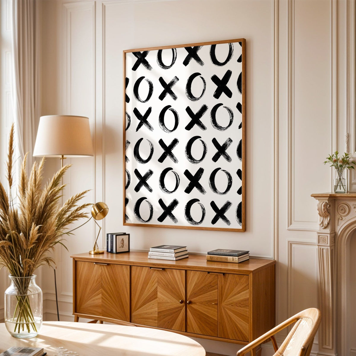 Hand-brushed XOXO pattern print in an oak frame above a sunburst wood sideboard with pampas grass