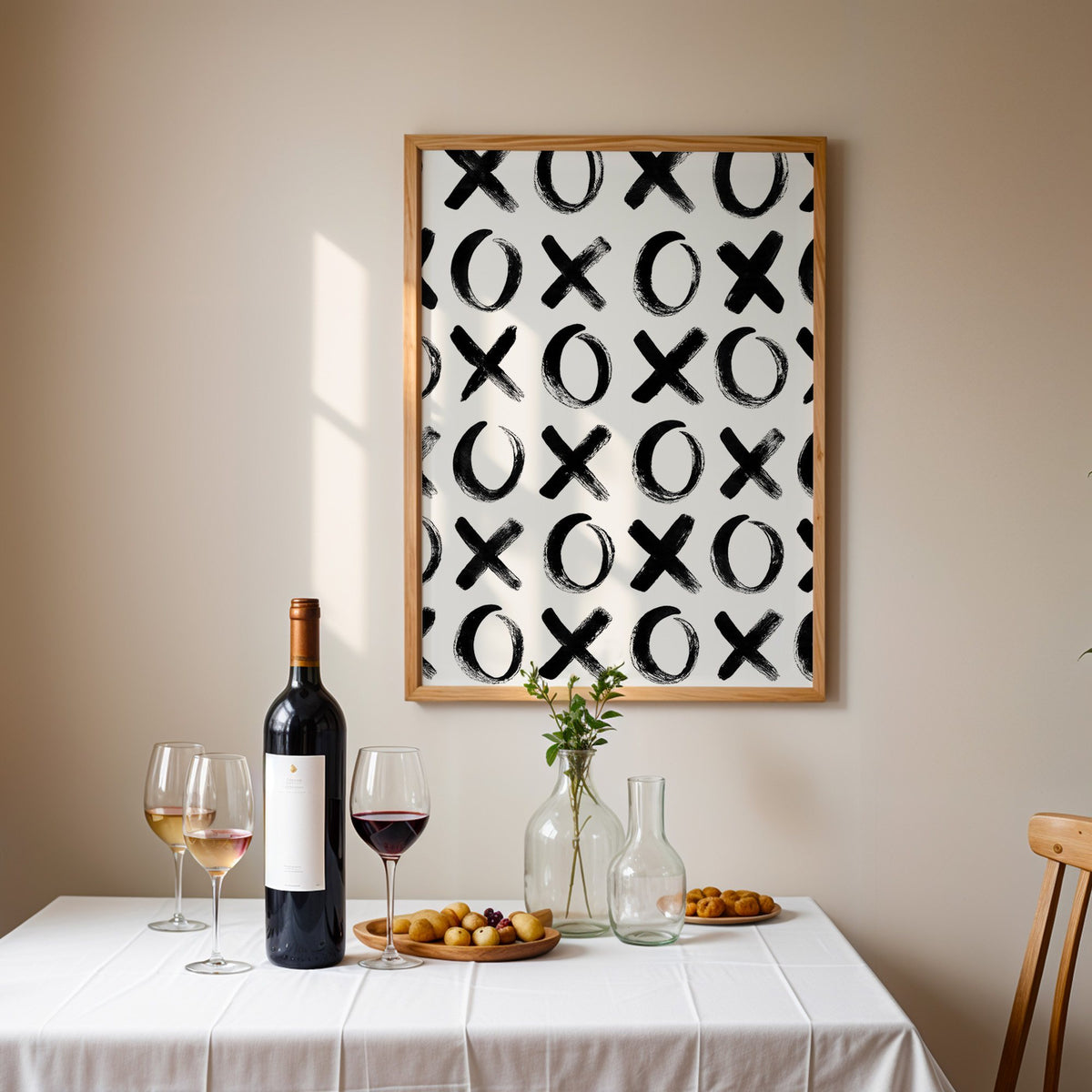 Hand-brushed XOXO pattern print in an oak frame above a table set with red wine and glasses
