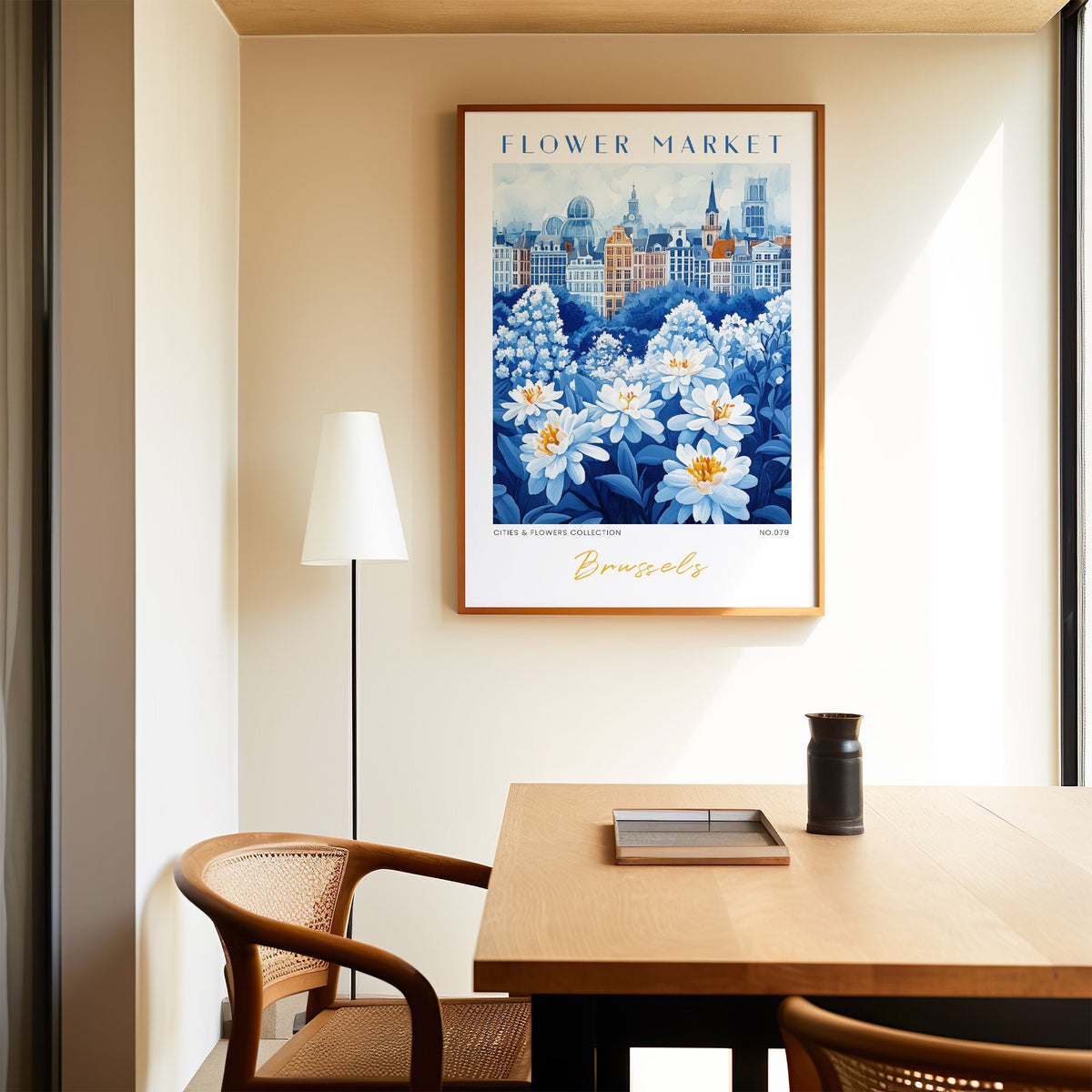 Brussels flower market print in an oak frame above a dining table and cane chair