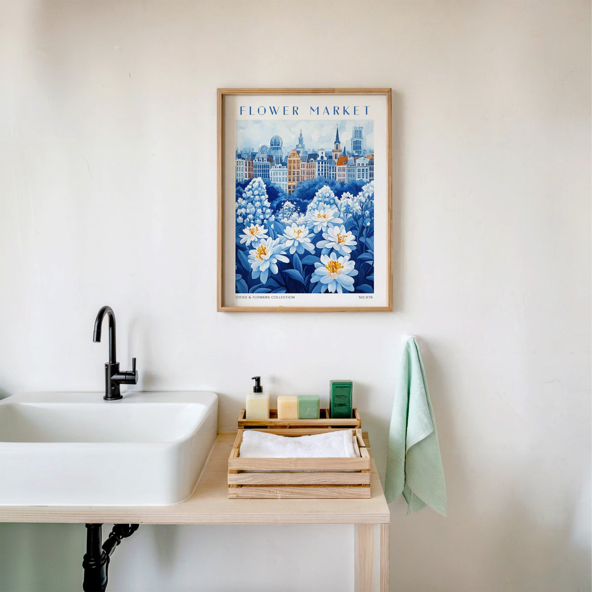 Brussels flower market print in an oak frame above a white bathroom sink with folded towels