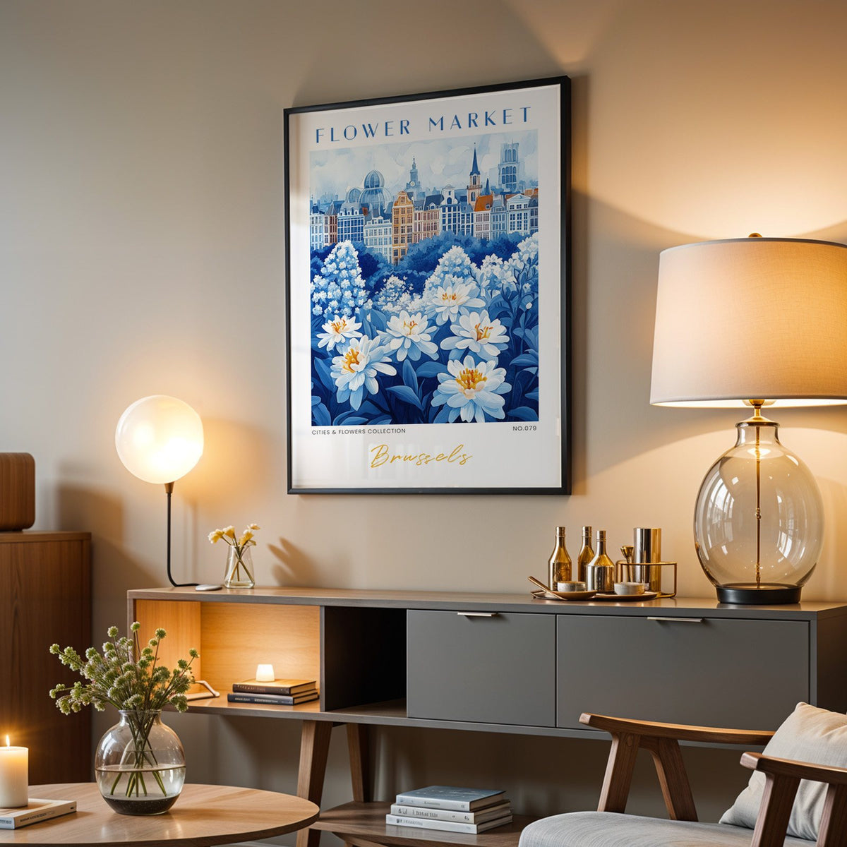 Brussels flower market print in a black frame above a grey media console with a glass table lamp