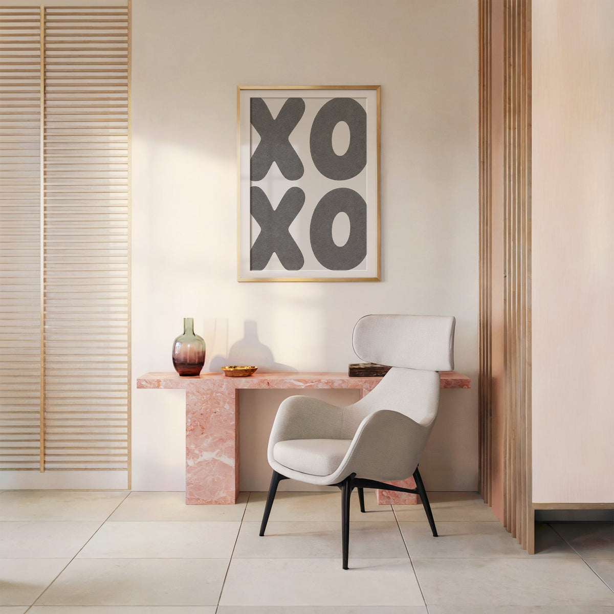 Giant grey bubble letters spelling XOXO print shown in a gold frame above a pink marble console and armchair