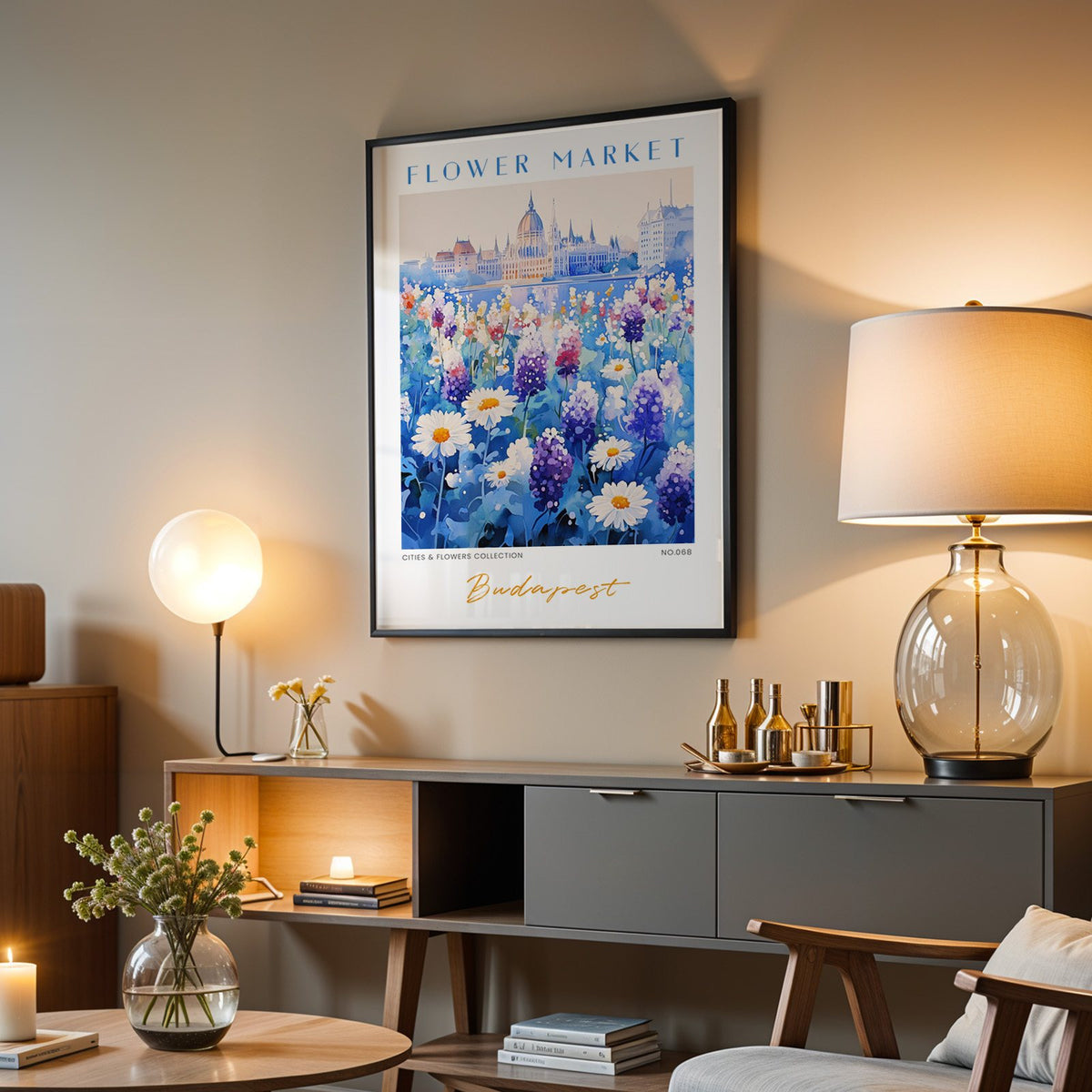 Budapest flower market print in a black frame above a grey media console with a glass table lamp