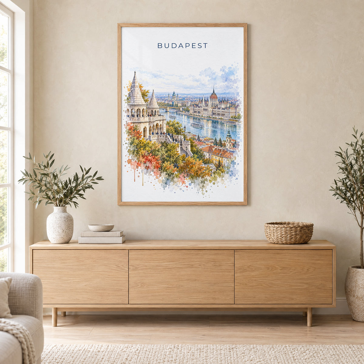 Budapest watercolor print in an oak frame above a light wood sideboard in a Scandinavian living room