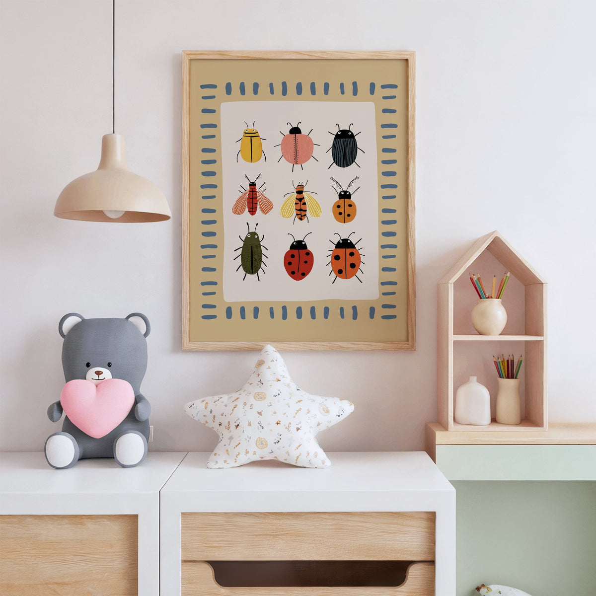 Bug collection chart nursery print in an oak frame above a white dresser with a star pillow and house shelf