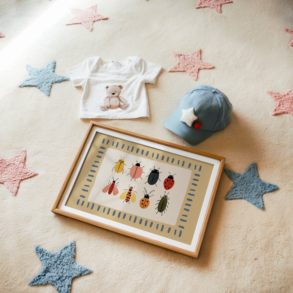 Landscape bug collection chart nursery print in a matted oak frame on a star rug with a baby tee