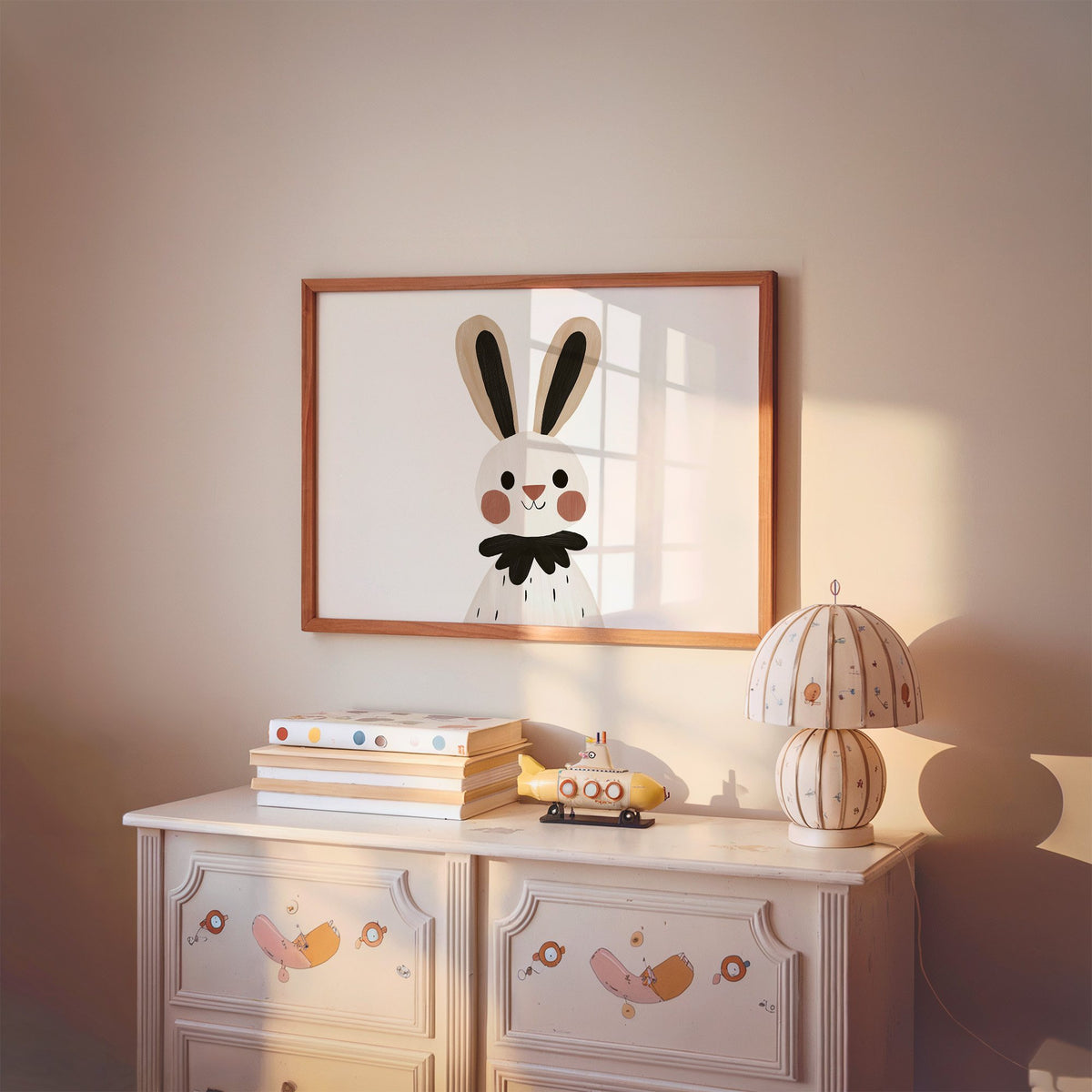 Landscape bunny black ruffle collar nursery print in a cherry wood frame above a painted dresser and lamp