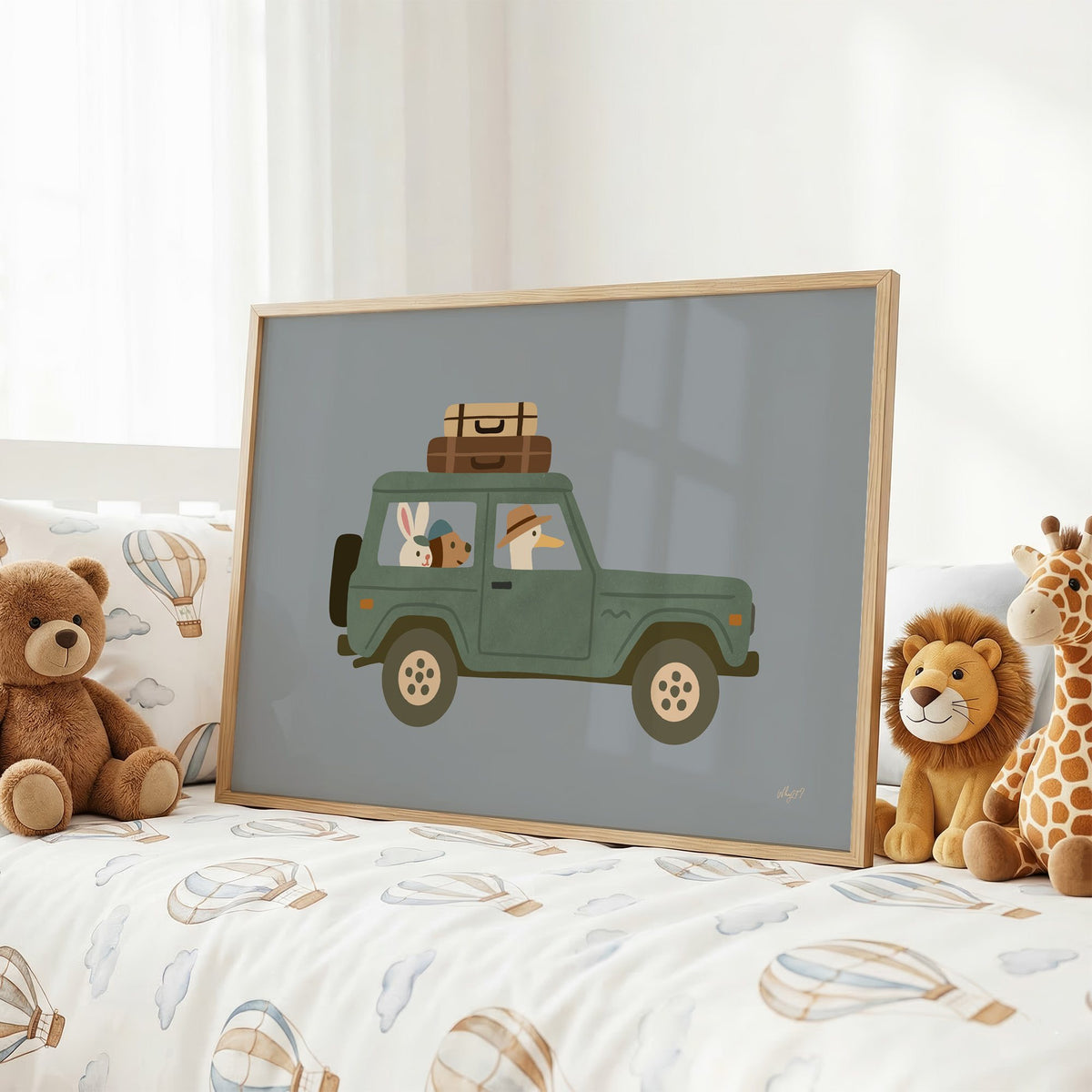 Animals riding green vintage suv nursery print in an oak frame on a kids bed with hot air balloon bedding