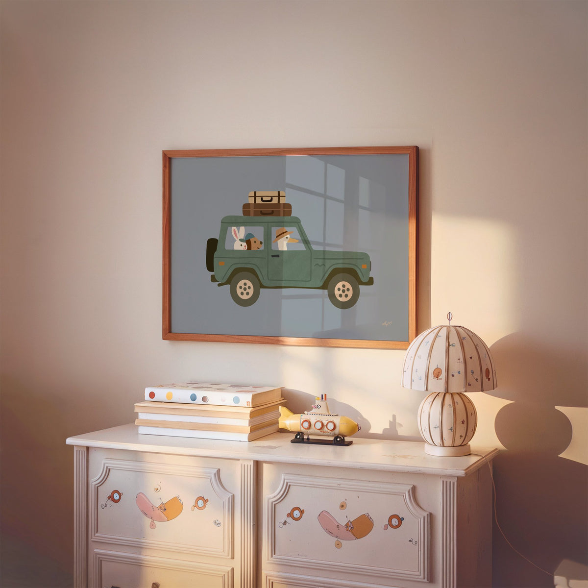 Animals riding green vintage suv nursery print in a cherry wood frame above a painted dresser and lamp