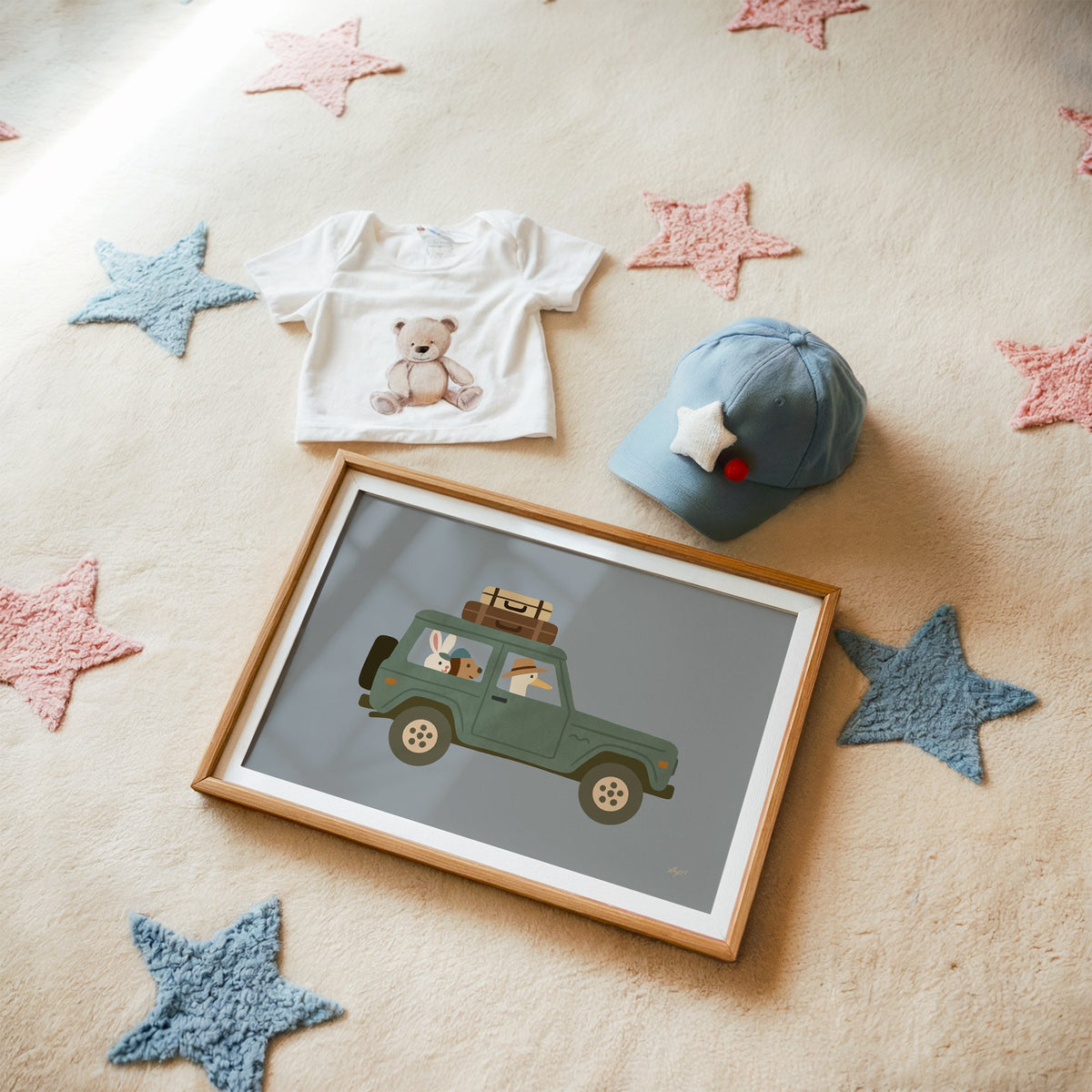 Animals riding green vintage suv nursery print in a matted oak frame on a star rug with a baby tee