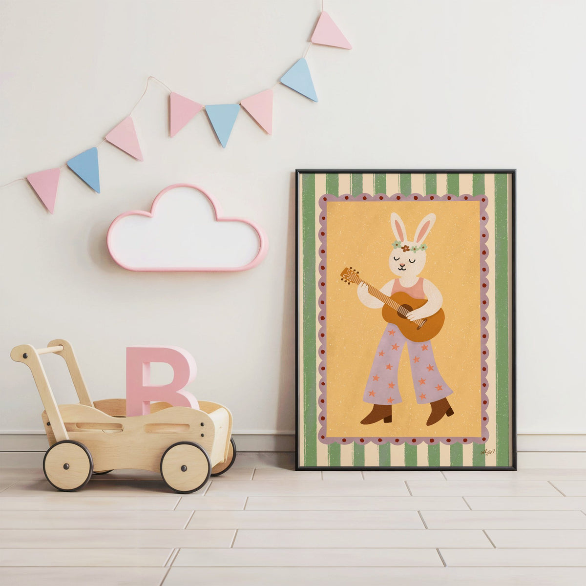 Bunny playing guitar with flower crown nursery print in a black frame under pastel bunting by a wooden baby walker