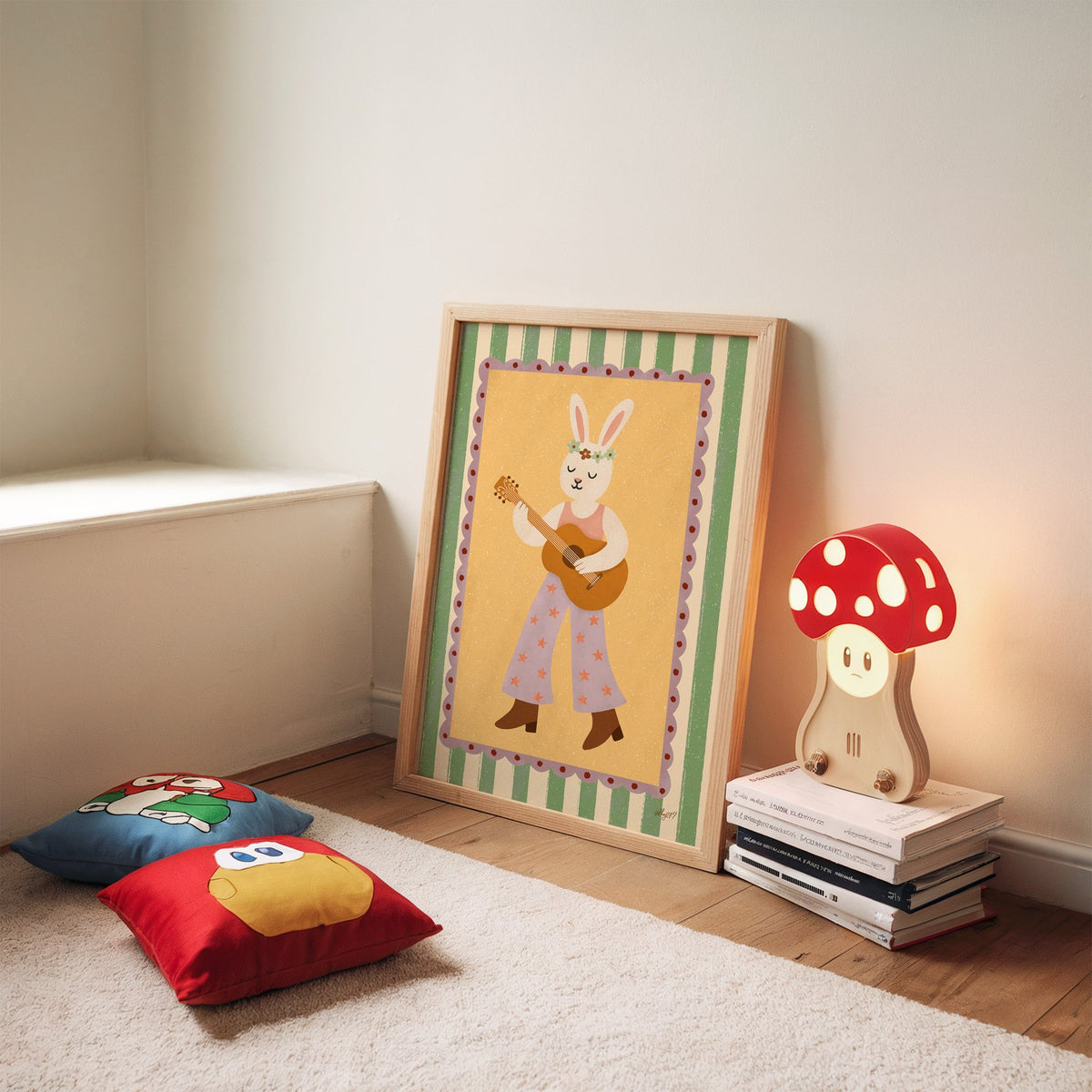 Bunny playing guitar with flower crown nursery print in an oak frame leaning on a rug beside a mushroom lamp and floor