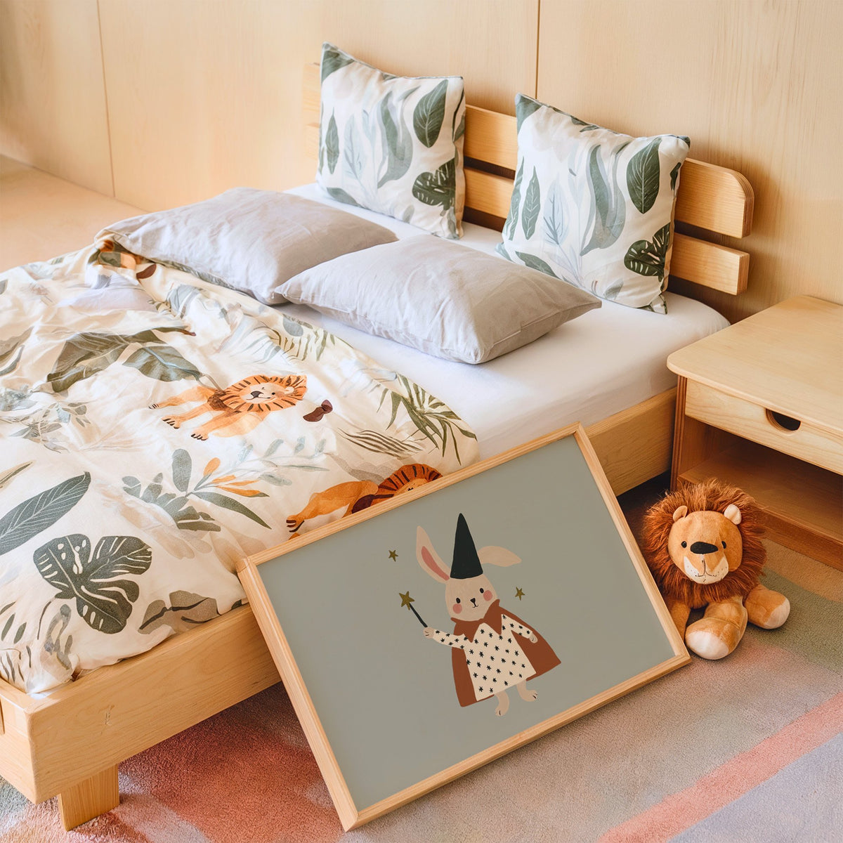 Landscape bunny magician star wand nursery print in an oak frame leaning on a kids bed by a lion plush