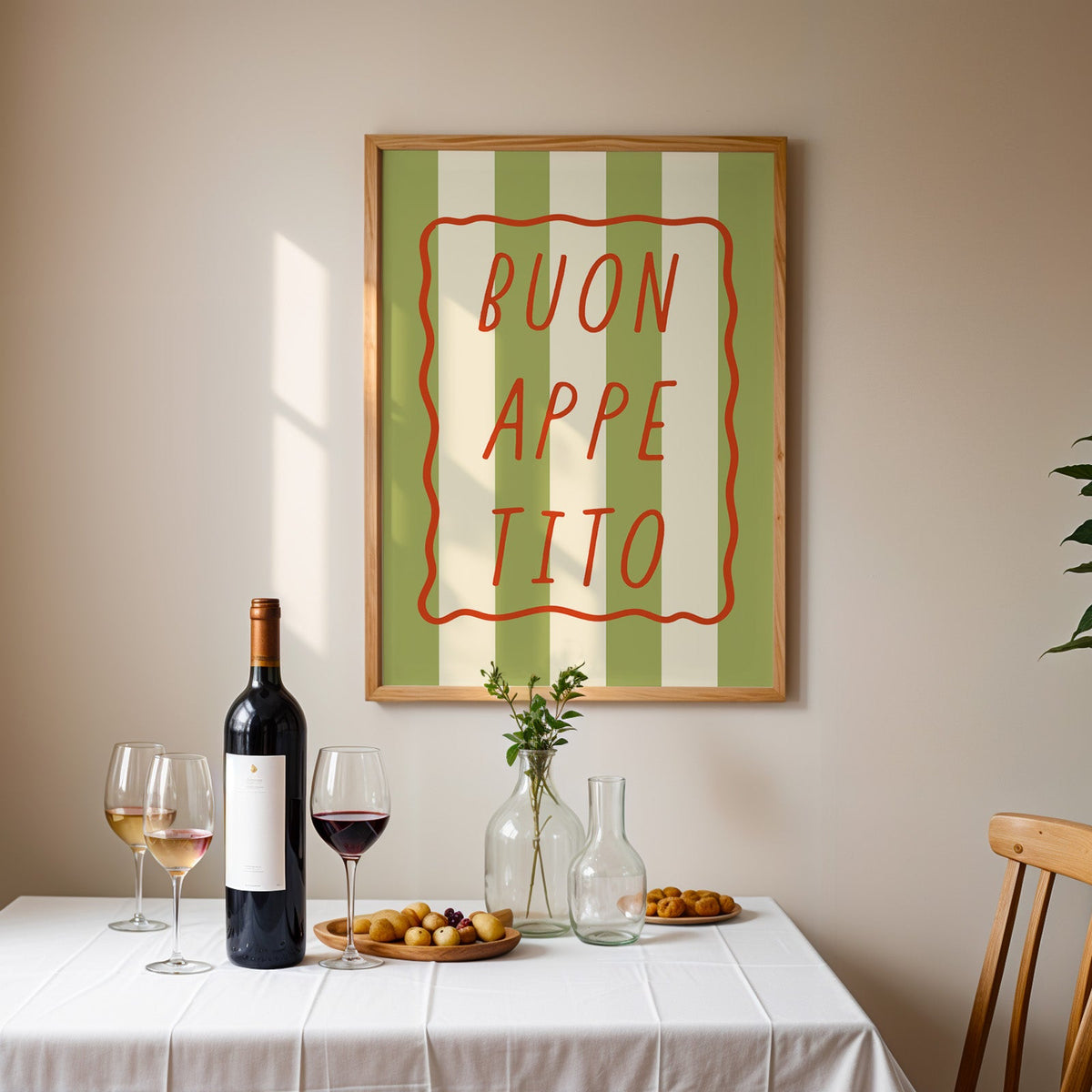 Buon appetito print in an oak frame above a table laid with red wine and glasses