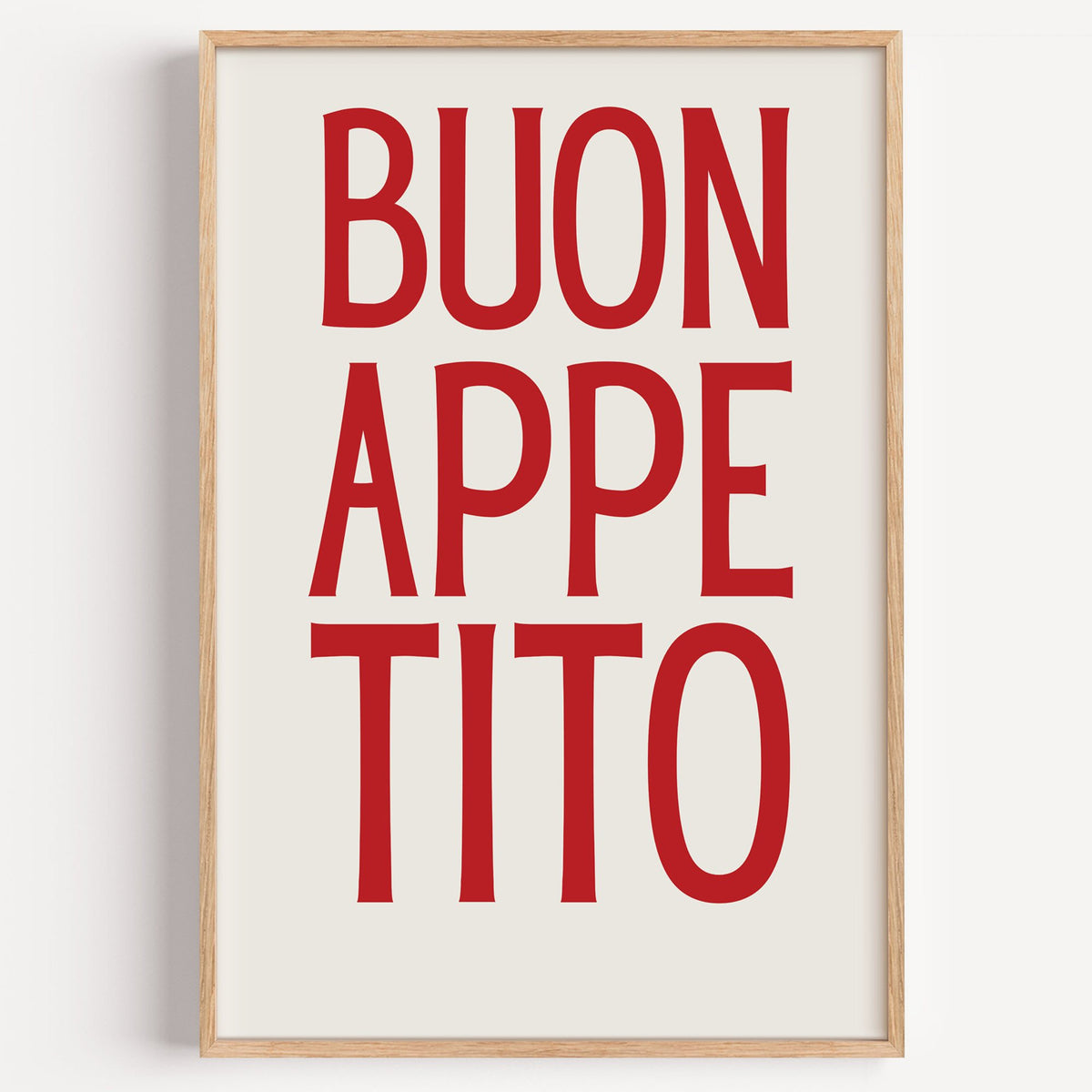 BUON APPE TITO red condensed type print in a light oak frame on a plain white wall