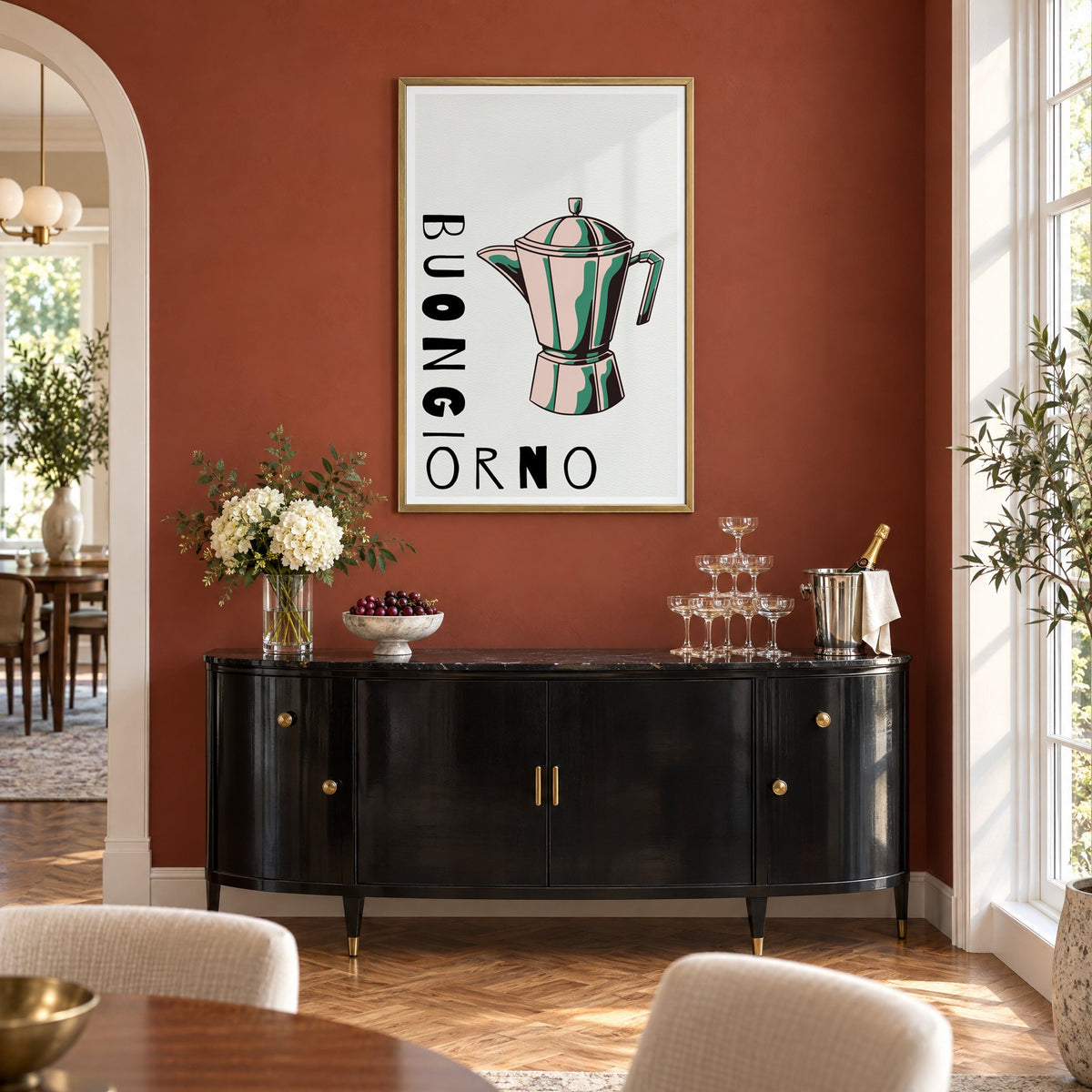 BUONGIORNO moka pot pop art print in a brass frame on a terracotta wall above a black buffet with a champagne tower