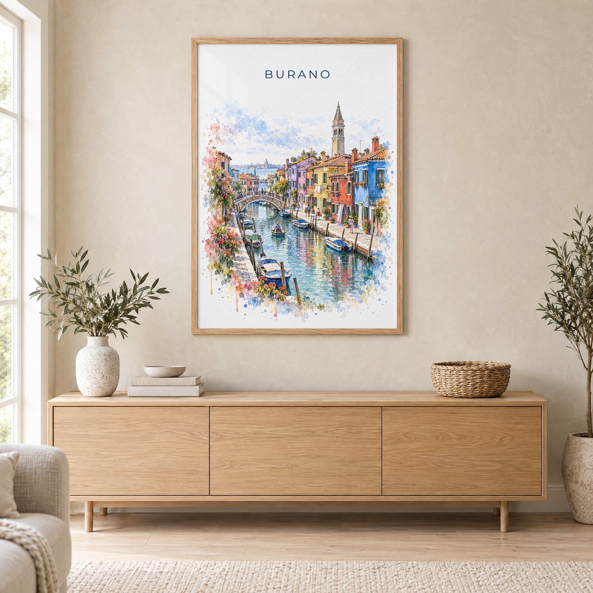 Burano watercolor print in an oak frame above a light wood sideboard in a Scandinavian living room