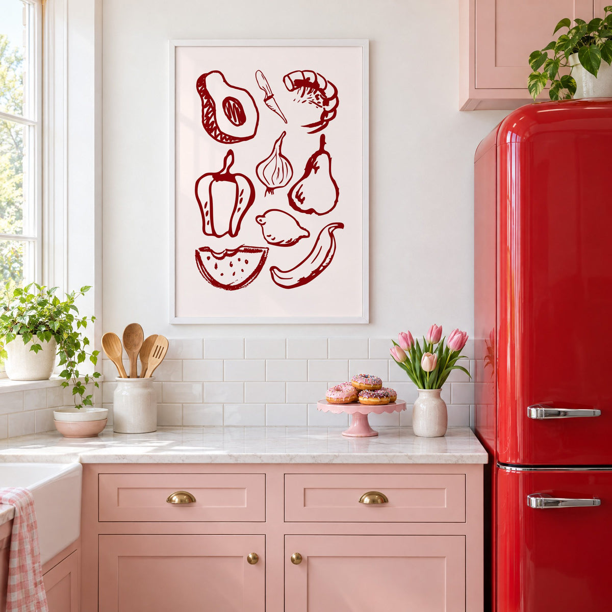 Burgundy line vegetables and fruit sketch print in a white frame above pink cabinets beside a red retro fridge