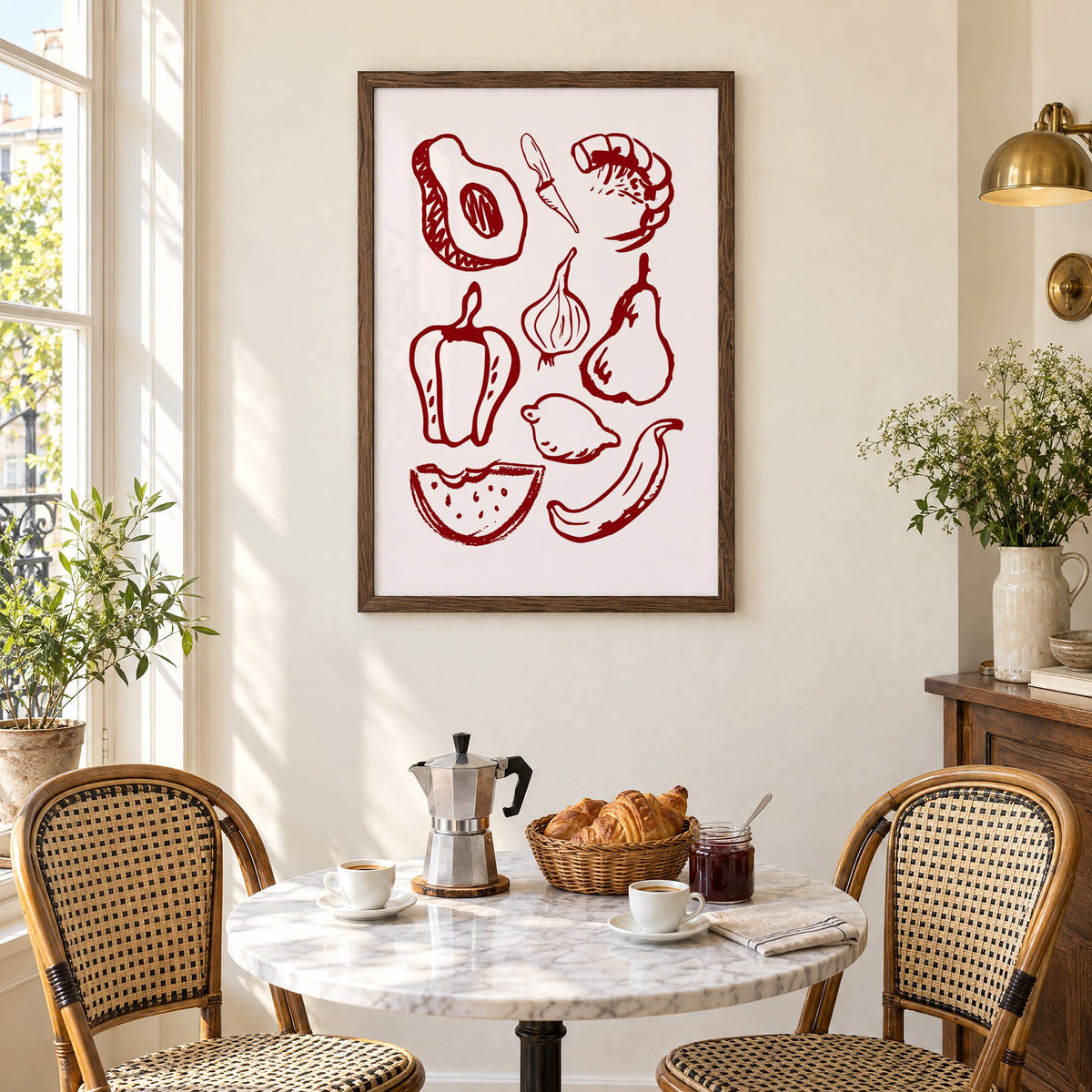 Burgundy line vegetables and fruit sketch print in a walnut frame above a marble bistro table with croissants and rattan chairs