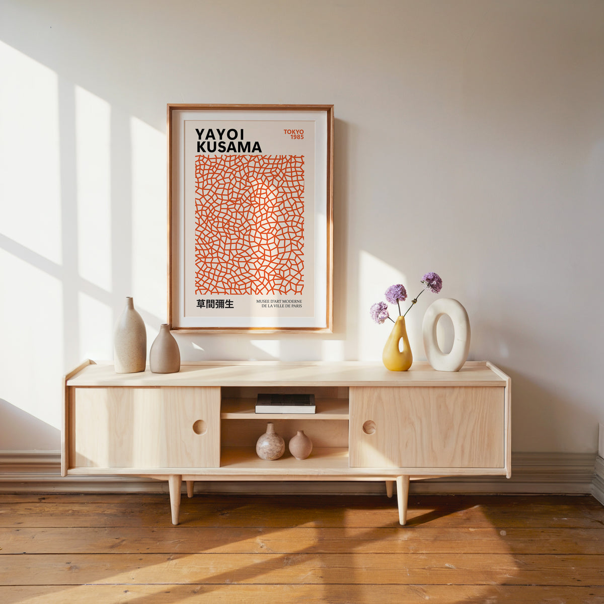Yayoi Kusama inspired burnt orange net print above a pale wood console