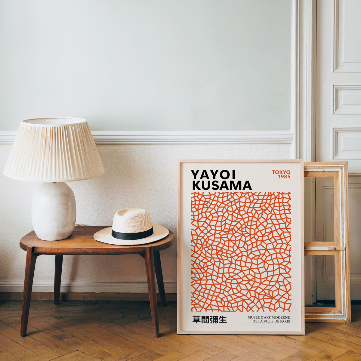 Yayoi Kusama inspired burnt orange net print beside a bench and straw hat
