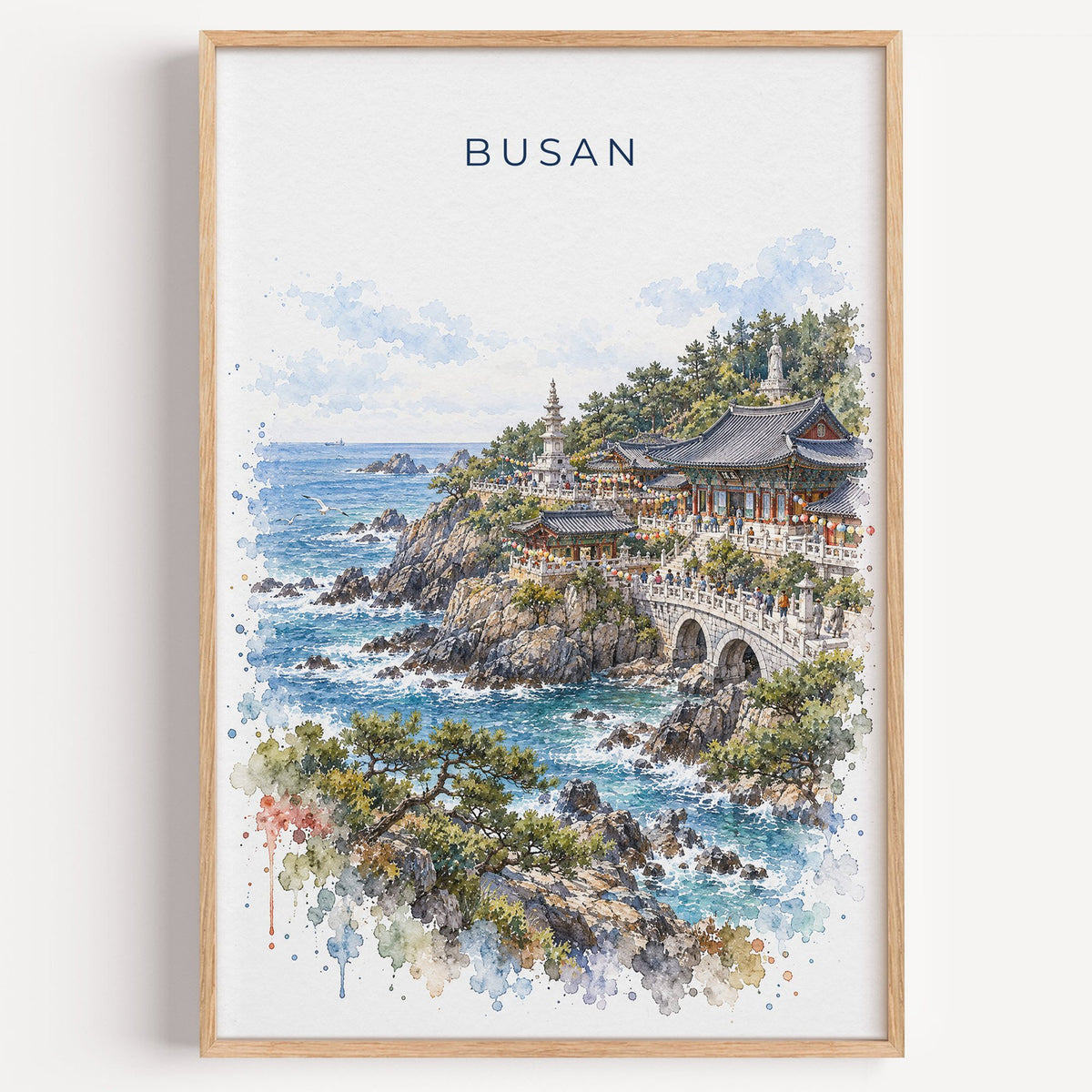 Busan watercolor print in a light oak frame on a plain white wall