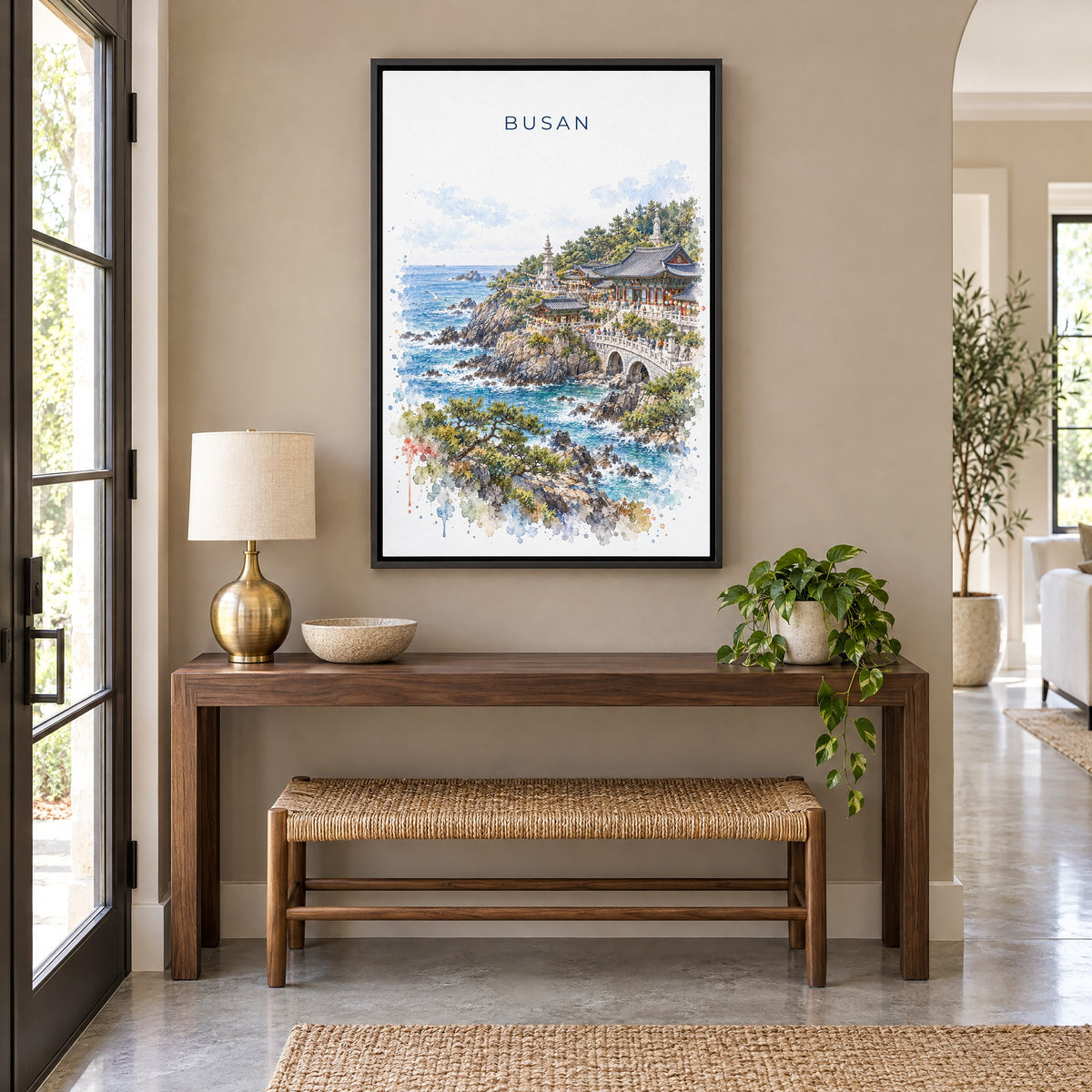 Busan watercolor print as a black floater canvas above a walnut console and woven bench in an entryway