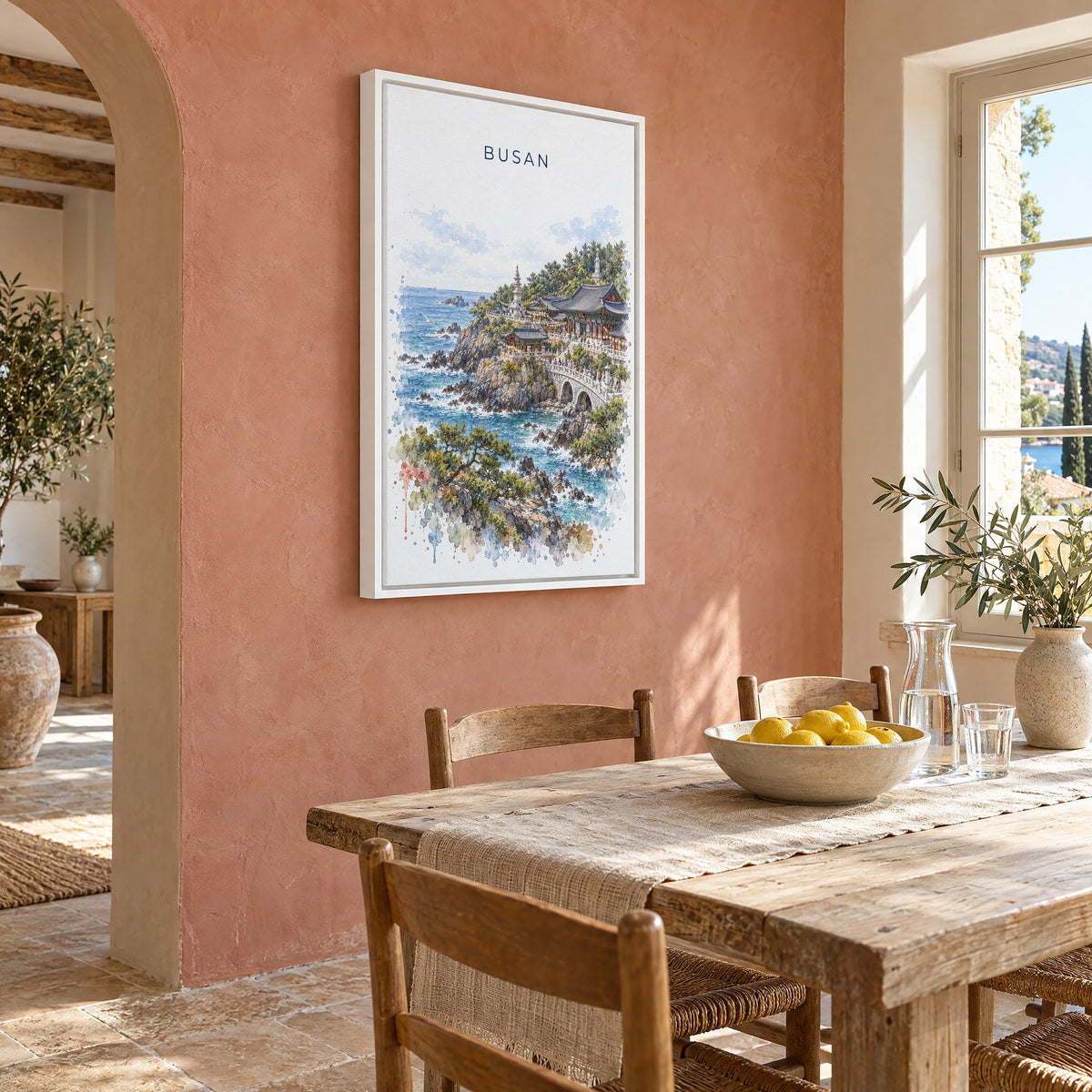 Busan watercolor print as a white floater canvas on a terracotta wall above a rustic dining table