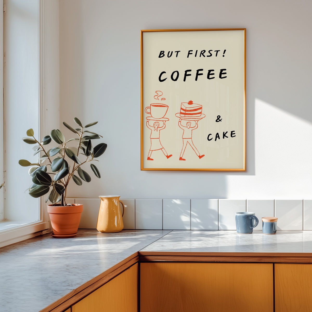 But First Coffee and Cake print shown in a gold frame above a marble counter with a yellow ceramic jug