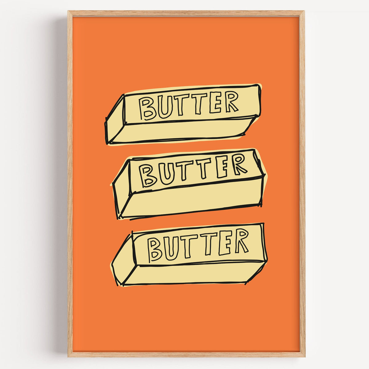 Butter blocks print in a light oak frame on a plain white wall