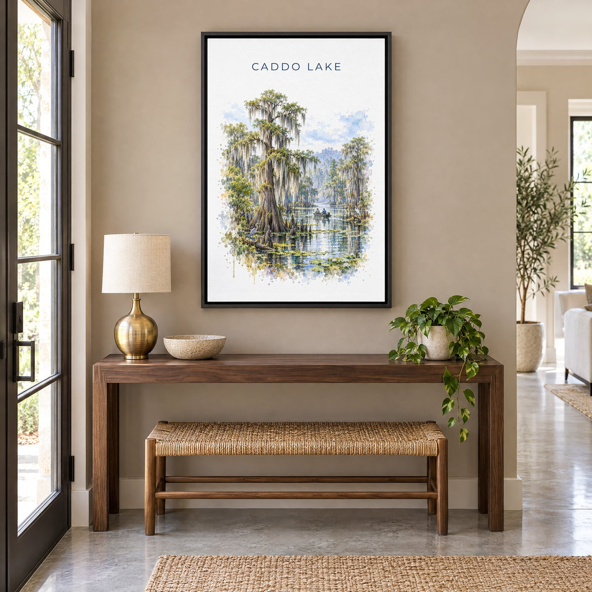 Caddo Lake watercolor print as a black floater canvas above a walnut console and woven bench in an entryway