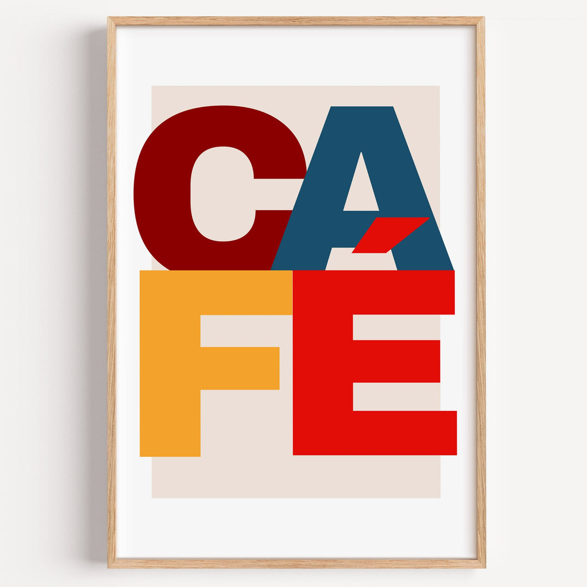 CA FÉ color block letters print in a light oak frame on a plain white wall