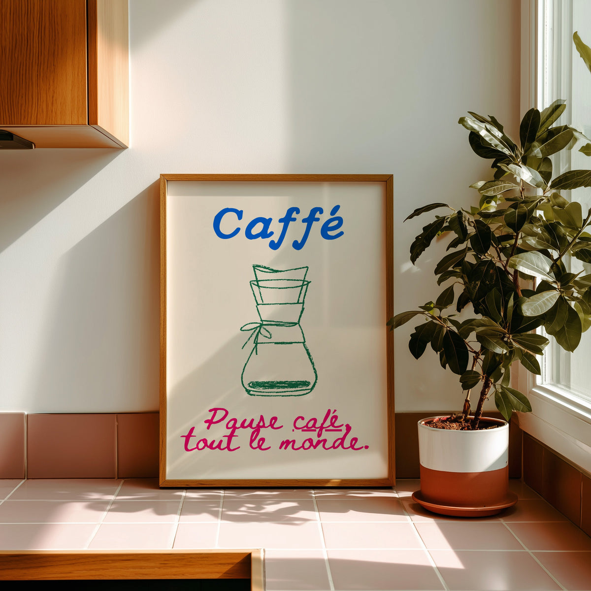 Chemex pause cafe coffee print in a golden oak frame leaning on a pink tiled ledge in strong afternoon sun