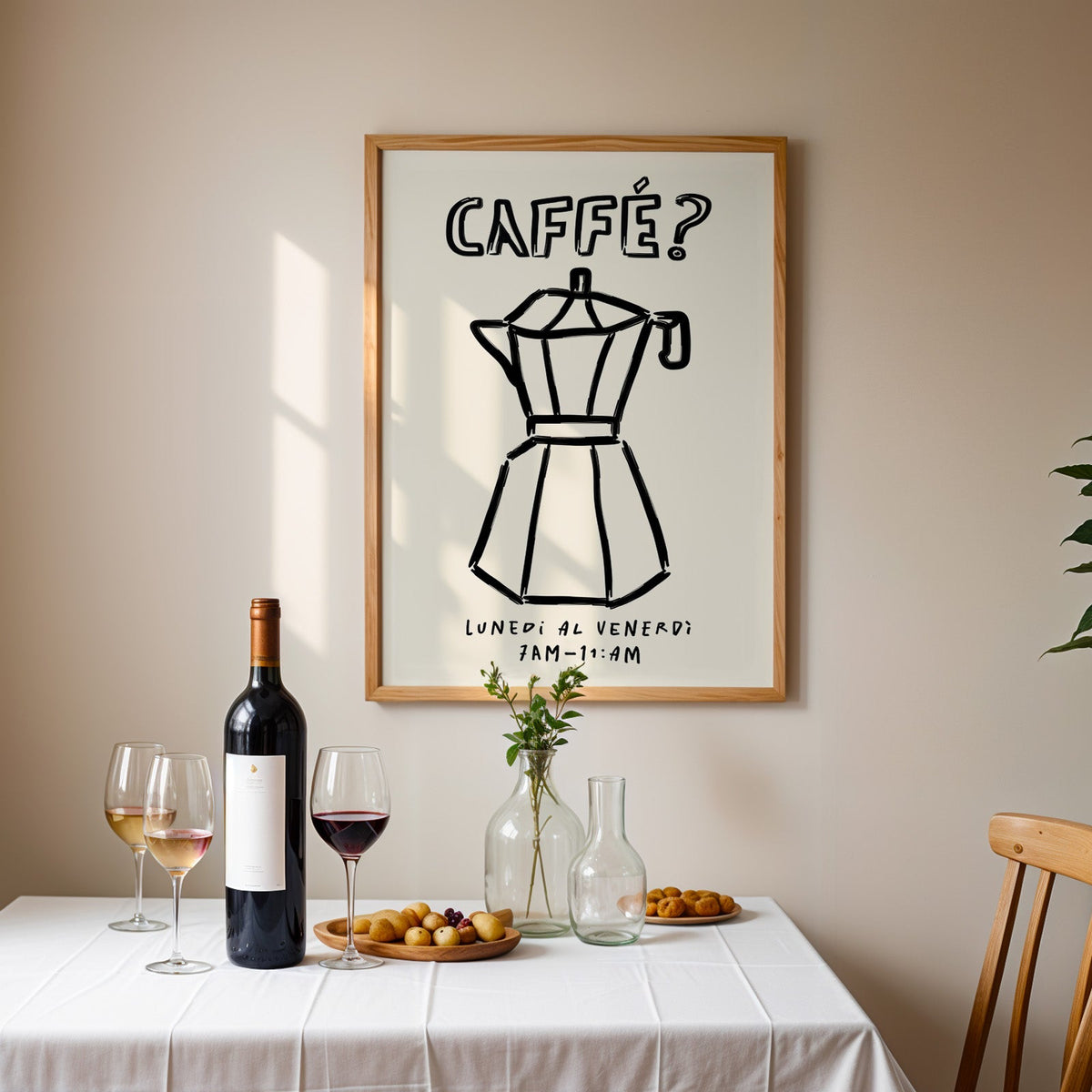 Black line moka pot print in an oak frame above a table laid with wine and glasses