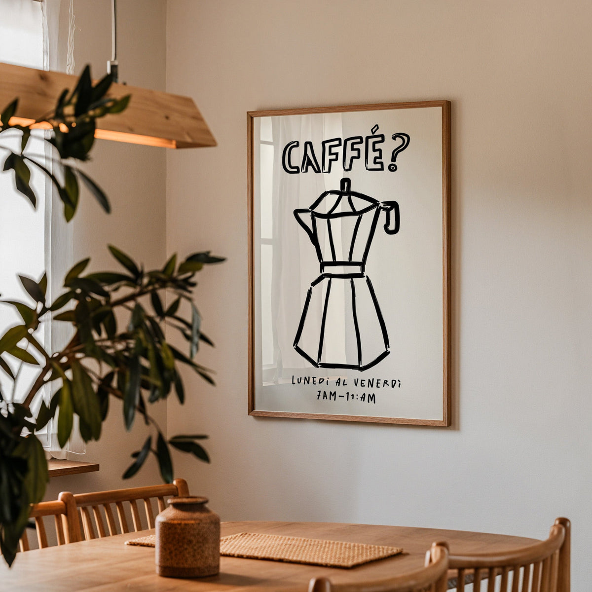 Black line moka pot print in a walnut frame above a dining table by an olive tree