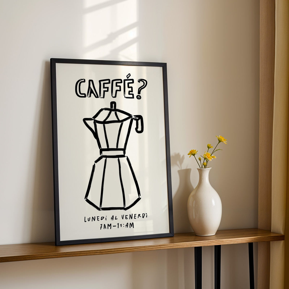 Black line moka pot print in a black frame on a console table with yellow daisies