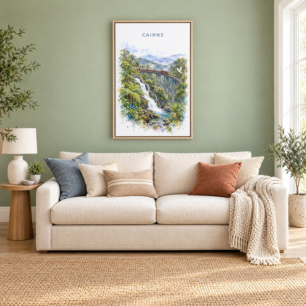 Cairns, Australia watercolor print as a natural floater canvas above a cream linen sofa on a sage green wall