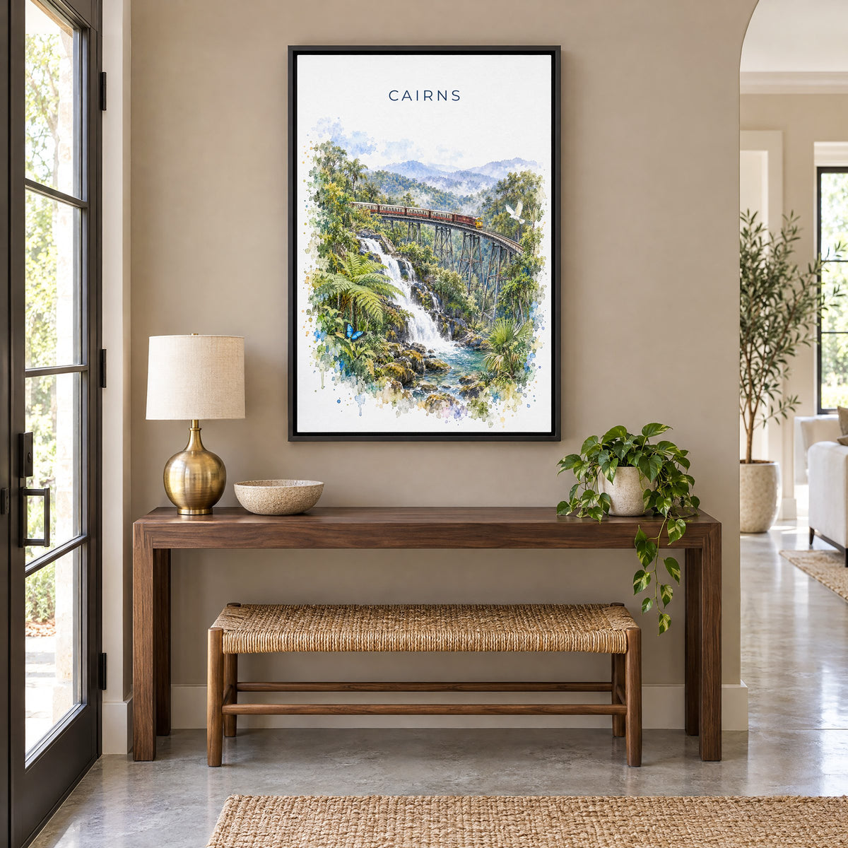 Cairns, Australia watercolor print as a black floater canvas above a walnut console and woven bench in an entryway