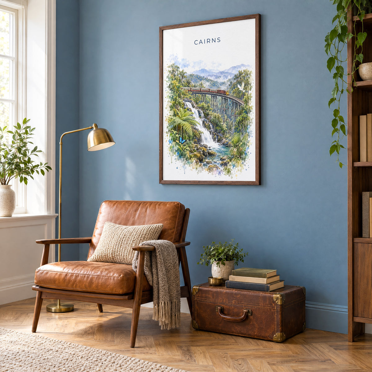 Cairns, Australia watercolor print in a walnut frame on a blue wall above a leather armchair in a reading nook