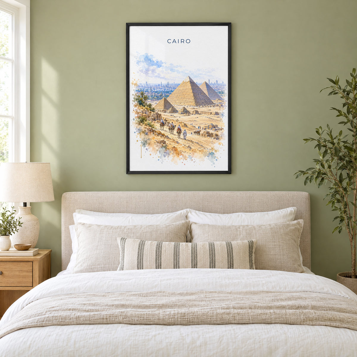 Cairo watercolor print in a black frame above an upholstered headboard in a sage green bedroom