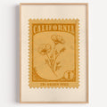 California state flower stamp print in amber gold on tan, light oak frame on a plain white wall