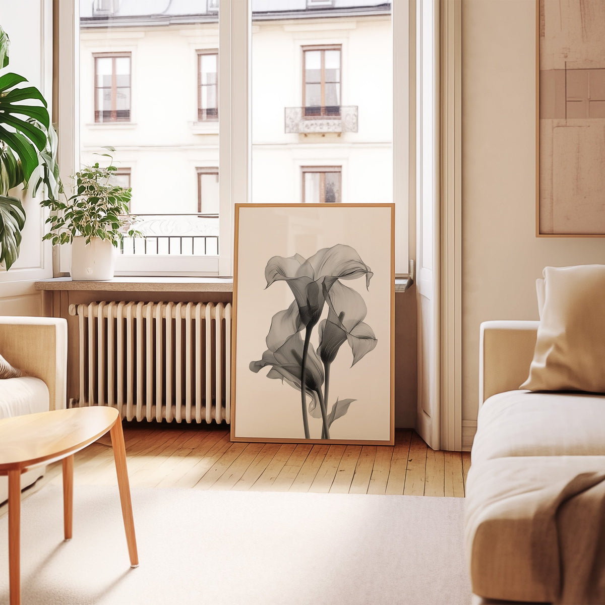 Translucent calla lily X-ray flowers print in an oak frame leaning by a French window in a living room