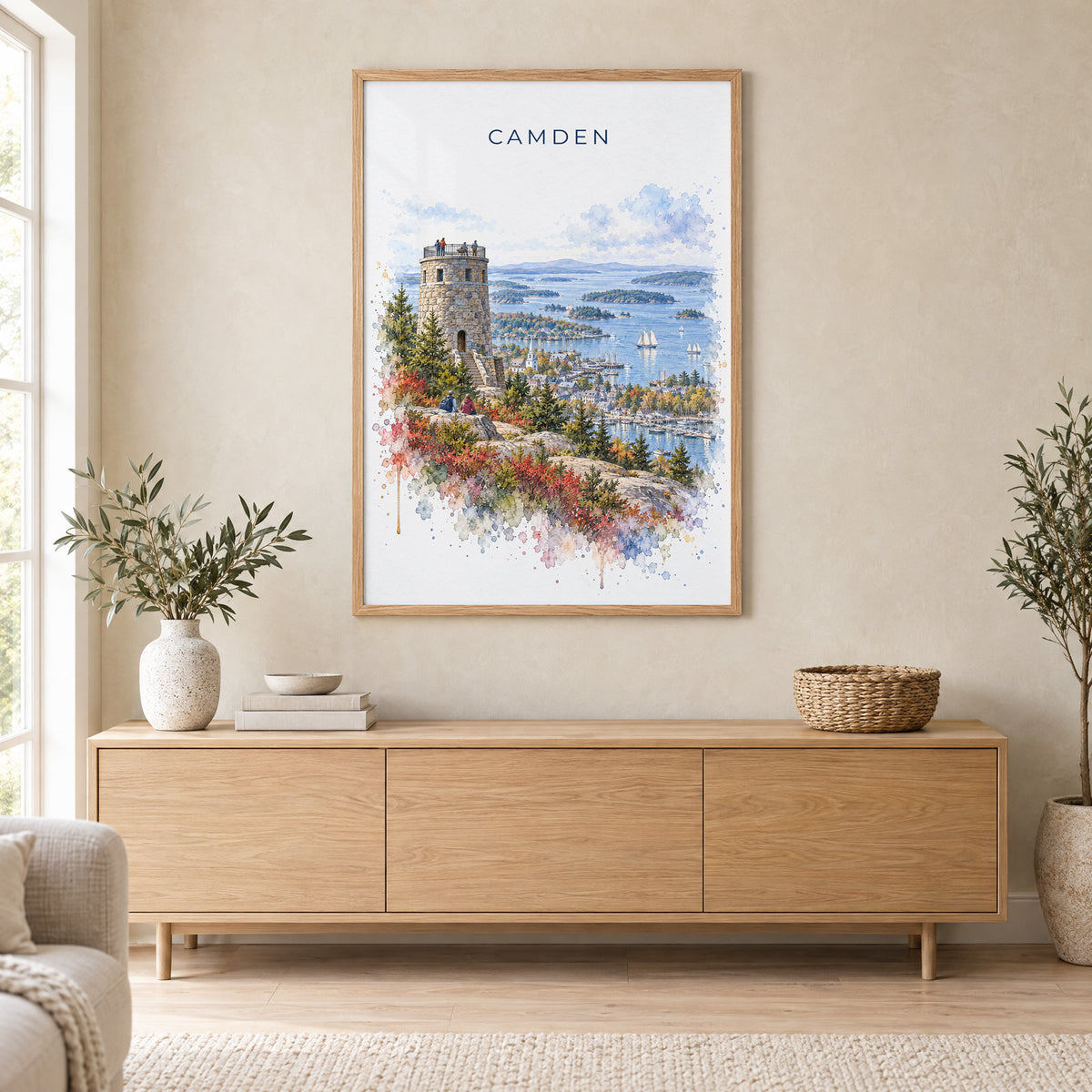 Camden, Maine watercolor print in an oak frame above a light wood sideboard in a Scandinavian living room
